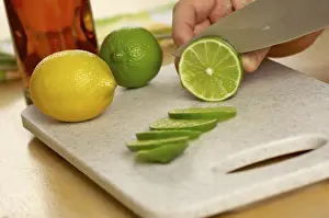 Chopping Board Images Drucke: Slicing a lime on a cutting board