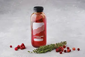 Colorful Tableware Drucke: Small bottle with cranberry and thyme lemonade on the table