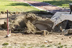 Pool Installation Process Drucke: Small bulldozer digging in yard for pool installation