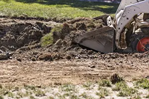 Bulldozer Construction Site Drucke: Small bulldozer digging in yard for pool installation