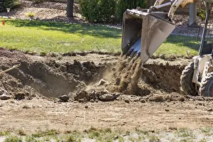 Pool Installation Process Drucke: Small bulldozer digging in yard for pool installation