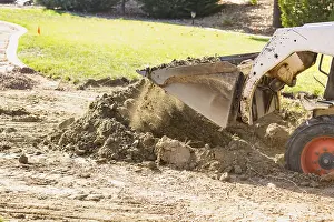 Pool Installation Process Drucke: Small bulldozer digging in yard for pool installation