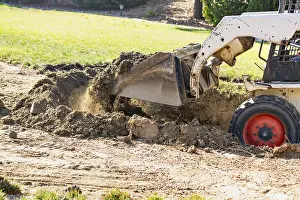 Pool Installation Process Drucke: Small bulldozer digging in yard for pool installation