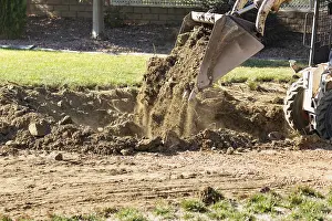 Pool Installation Process Drucke: Small bulldozer digging in yard for pool installation