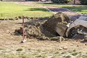 Swimming Pool Building Process Drucke: Small bulldozer digging in yard for pool installation