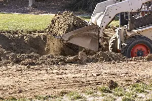 Bulldozer Construction Site Drucke: Small bulldozer digging in yard for pool installation