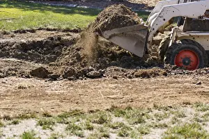 Agricultural Machinery Use Drucke: Small bulldozer digging in yard for pool installation