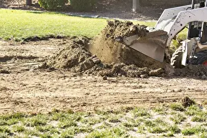Pool Installation Process Drucke: Small bulldozer digging in yard for pool installation