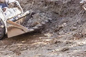 Construction Site Equipment Drucke: Small bulldozer digging in yard for pool installation
