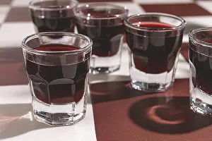 Alcoholic Beverages Drucke: There are small glasses with a red drink on the table