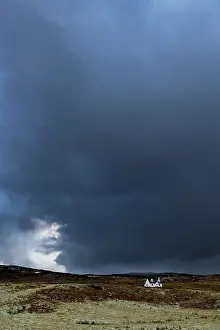 Stormy Weather In Europe Drucke: Small house in front of a dark storm cloud