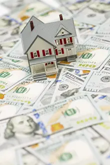 Residential Building Cost Drucke: Small model house on layer of one hundred dollar bills