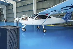 Commercial Aviation Industry Drucke: Small propeller plane parked inside a clean