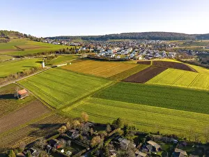 Evening Atmosphere Europe Drucke: Small village with fields in the evening light