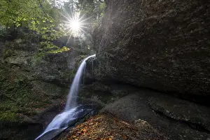 Southern Germany Landscape Drucke: A small waterfall flows over rocks and is illuminated by the sun's rays