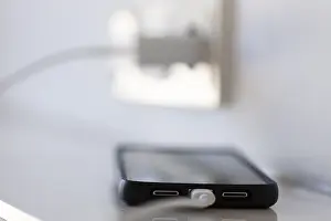 German Power Industry Drucke: A smartphone is charged via a socket