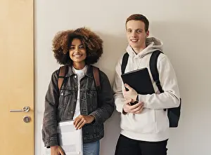Male Looking At Camera Drucke: Two smiling classmates standing together at wall and looking at camera