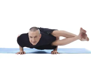 Meditation And Wellbeing Drucke: Smiling flexible man posing in difficult yoga pose