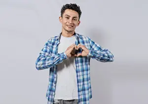 Symbolic Heart Shape Image Drucke: Smiling guy making heart shape with hands isolated