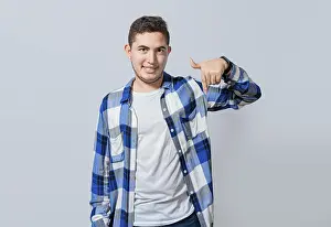Male Facial Expression Drucke: Smiling guy pointing down with one hand isolated