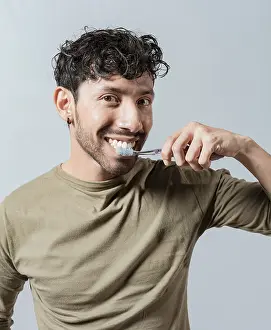 Dental Care Drucke: Smiling man brushing his teeth isolated