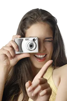 Fashion Model Drucke: Smiling model holding digital camera and making a shot