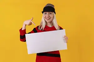 Yellow Background Studio Shot Drucke: Smiling pointing to an empty ad poster