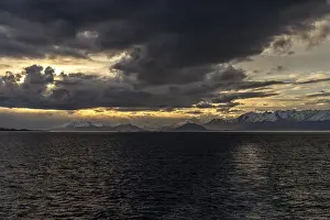 Deserted Evening Sun Scene Drucke: Snow-covered mountain range with dramatic cloud vibes at sunset