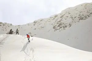 Powder Snow Drucke: Two snowboarders gracefully glide down a pristine