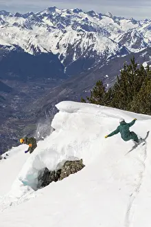 Mountainous Winter Scenery Drucke: Two snowboarders skillfully navigate a steep