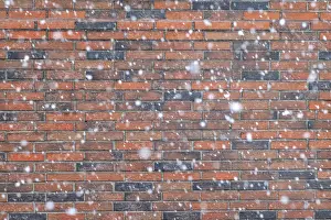 Bilder Datiert 14. Januar 2024: Schneeflocken vor einem Ziegelmauer.