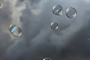 Empty Desert Landscape Drucke: Soap bubbles iridescent, floating in front of dark clouds