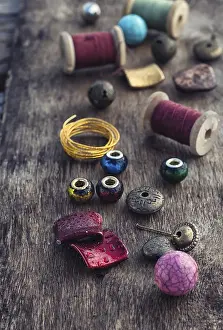 Handicraft Accessories Drucke: The spool of thread, beads and wire for needlework on wooden background