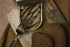 Drucke von Sardinen in Butter, mit schwarzem Brot, gekochter geräucherter Fisch in Dosen, offen, Nahansicht, Oberblick, keine Menschen Sprotte Drucke: Sardinen in Butter, mit Schwarzbrot.