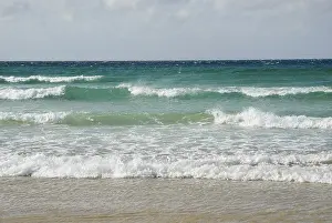 Deserted Irish Beach Drucke: Spray blown by high winds, rolling crushers