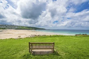 Drucke von St. Ives, England - Juni 2018 : Leere Holzbank für müde Wanderer auf dem Küstenweg entlang der Cornish Küste mit einem Blick auf Porthmeor-Strand, Cornwall Porthmeor Drucke: St. Ives, England - Juni 2018