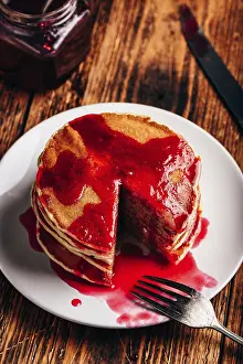 American Pancakes Drucke: Stack of american pancakes with red berry jam on plate over rustic surface