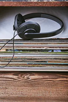 Vinyl Record Collection Drucke: Stack of many black vinyl records and headphones put on the top of stack