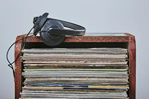 Stack of many black vinyl records and headphones put on the top of stack
