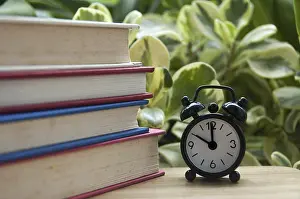 Copy Space Concept Drucke: Stack of books with alarm clock pointing at 10 o'clock