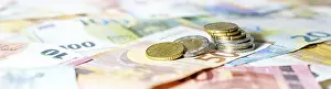 Economic Crisis Image Drucke: Stack of coins on euro banknotes as wide panoramic format