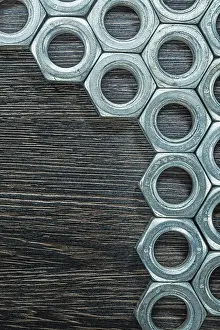 Industrial Construction Industry Drucke: Stack of construction nuts on wooden board