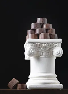 Food Still Life Composition Drucke: Stack of fine artisan chocolates stacked on white pillar column