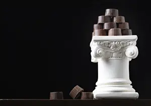Empty Pastry Shop Drucke: Stack of fine artisan chocolates stacked on white pillar column