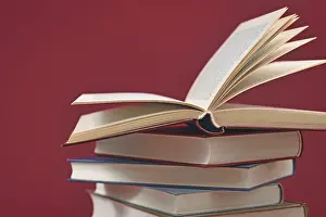 Educational Institution Background Drucke: Stack of old hardcover books on dark red background