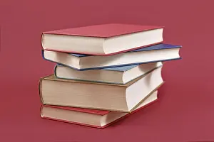 University Building Drucke: Stack of old hardcover books on dark red background