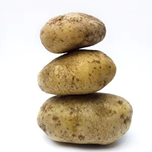 Organic Potatoes Drucke: A stack of organic potatoes on white background