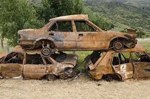 Deserted Junkyard Scene Drucke: Stack of three rusty car wrecks