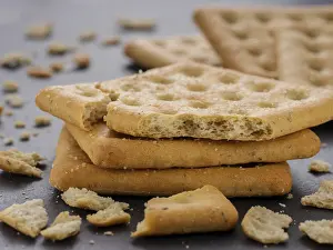 Savory Meal Starters Drucke: Stack of square crackers with pieces and crumbs on slate gray background