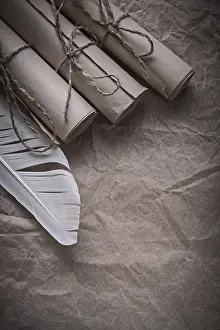 Deserted Table Setting Drucke: Stack of vintage paper scrolls feather on crumpled wrapping sheet